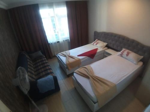 two beds in a room with a fan and a chair at Midtown Hotel Apartments 301 (2+1) in Istanbul