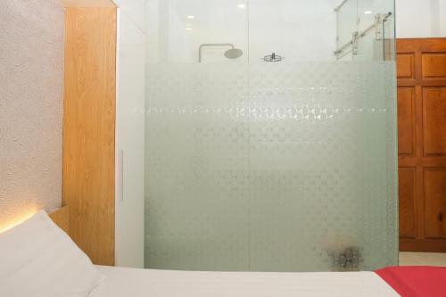 a glass shower in a bedroom with a bed at Lộc Thiên Ân hotel in Bien Hoa