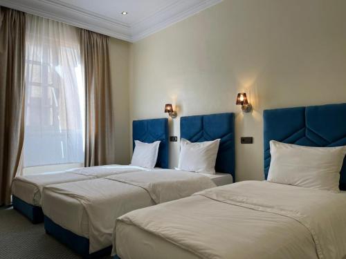 Habitación de hotel con 2 camas y ventana en Astoria, en Casablanca