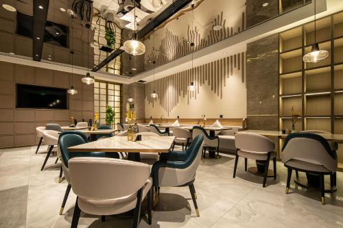 a restaurant with tables and chairs in a room at Atour Hotel Jiashan Dazhong Plaza in Jiashan
