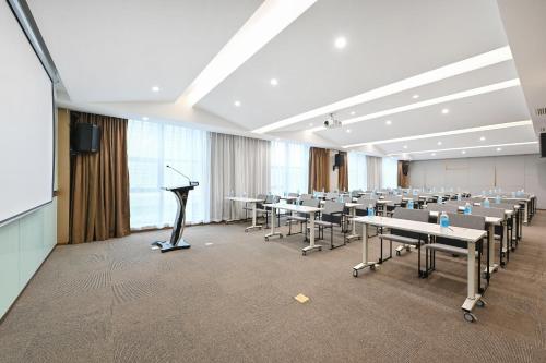 a conference room with tables and chairs and a podium at Atour Hotel Luliang Central Park in Luliang