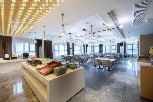 um restaurante com mesas e cadeiras numa sala grande em Atour Hotel Anqing Municipal Affairs Center Seventh Street em Anqing