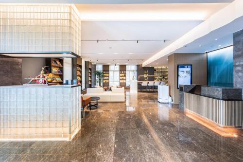 un hall ouvert avec un bar et un salon dans l'établissement Atour Hotel Lianyungang Municipal Affairs Central University Town, à Lianyungang