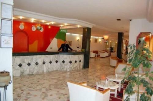 a man standing at a bar in a restaurant at Hotel Sindbad Sousse in Sousse