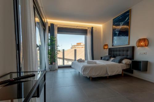 a bedroom with a bed and a large window at Edificio Santiago by Plaza Mayor Apartamentos in Valladolid