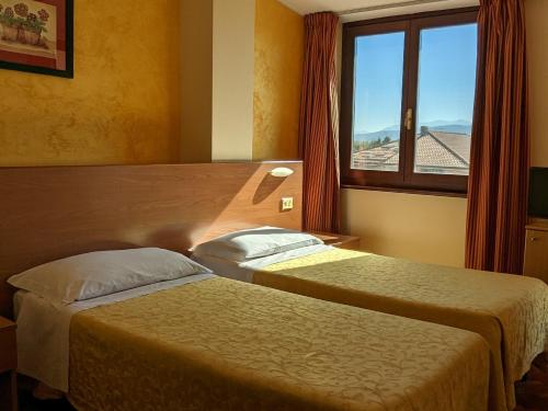 two beds in a hotel room with a window at Hotel Del Sole in Sora