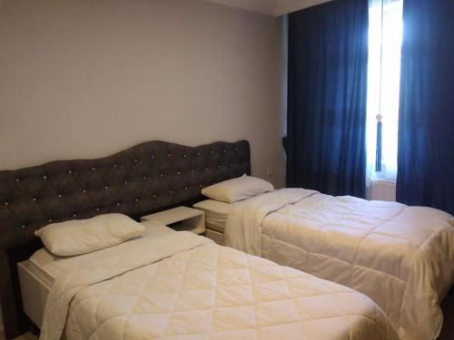 una camera d'albergo con due letti e una finestra di Midtown Hotel Apartments 103 (2+1) a Istanbul
