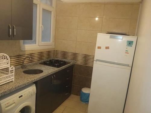 una cucina con frigorifero bianco e lavandino di Midtown Hotel Apartments 103 (2+1) a Istanbul