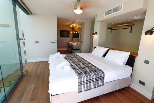 1 dormitorio con 1 cama blanca grande y baño en Vistaport A - Luxury Villa, en Bodrum City