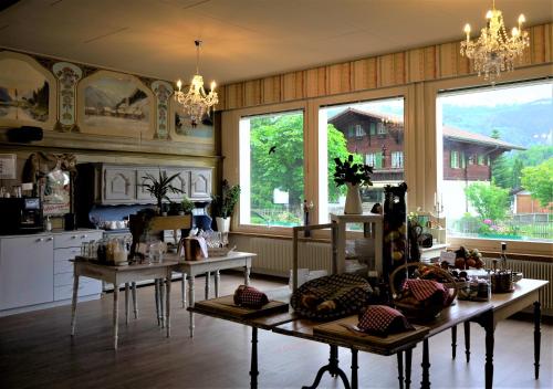 eine Küche mit 2 Tischen in einem Zimmer mit Fenstern in der Unterkunft Edelweiss Lodge in Wilderswil