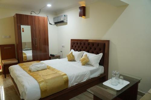 a bedroom with a large bed and a table at Classia Suites in Bengaluru