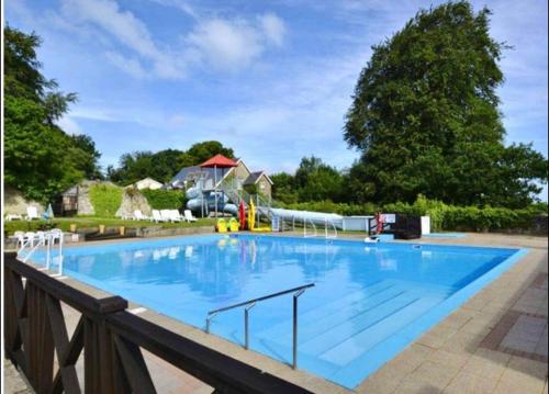 uma grande piscina azul com um escorrega aquático em Bucklands - Chalet 15 em Westward Ho