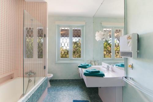 łazienka z 2 umywalkami, wanną i prysznicem w obiekcie Villa Bakéa - Plage 10mn à pied w mieście Saint-Jean-de-Luz