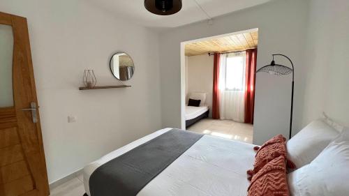 a bedroom with a white bed and a mirror at Villa Horizon in Saint-Joseph