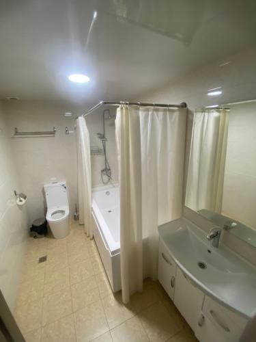 łazienka z wanną, toaletą i umywalką w obiekcie CENTRAL ASİA HOTEL w Taszkiencie