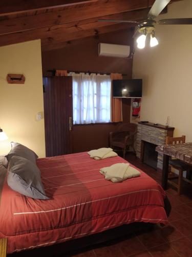um quarto com uma cama grande e um cobertor vermelho em Cabañas El Refugio em Chascomús