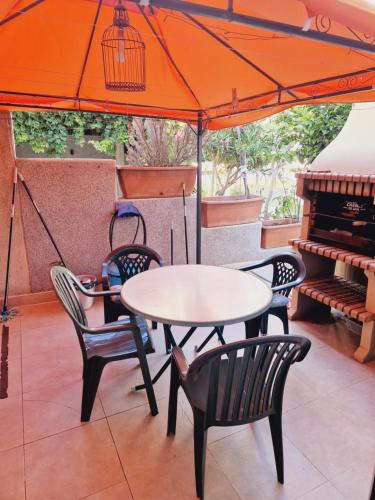 a table and chairs under an umbrella with a piano at Magnifico chalet adosado en Torrevieja, Alicante. in Torrevieja