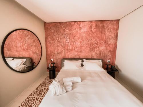 a bedroom with a large bed with a mirror at Ognissanti Restaurant Spa Hotel Rooftop in Trani