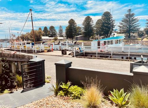 a marina with a boat docked at a dock at Edge17 Waterfront Apartment, plus Cottage with Garden View - Port Fairy in Port Fairy