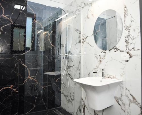 a bathroom with a sink and a mirror at Astra Hotel in Călimăneşti