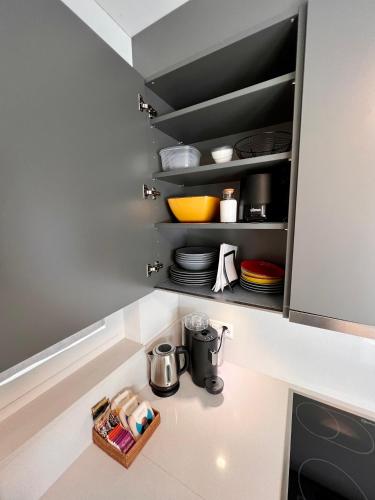 a kitchen with a cupboard with plates and utensils at MarAvilia Apartment - vicino a Splash & SPA Tamaro in Monte Ceneri