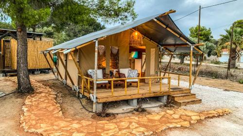 a small tent with a table and chairs in it at African Safari Canvas Lodge Tent Sea View in Kranidi