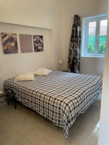 a bedroom with a bed with a checkered blanket at Moinho Da Asneira - Duna Parque Resorts & Hotels in Vila Nova de Milfontes