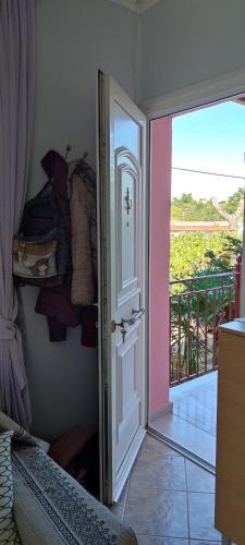 a room with a door open to a balcony at Maria's home in Órmos