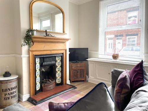 a living room with a fireplace and a mirror at The Racecourse - Quaint Victorian Home With Free Parking in York