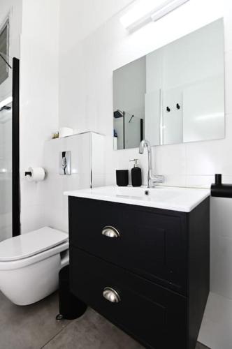 a bathroom with a sink and a toilet and a mirror at Gluck House in Migdal