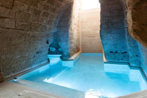 - une piscine d'eau dans une chambre située dans un bâtiment dans l'établissement Le Carasse Boutique Hotel, à Mola di Bari