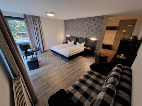 Habitación de hotel con cama y sofá en Nordic Avantage Hotel en Kiel