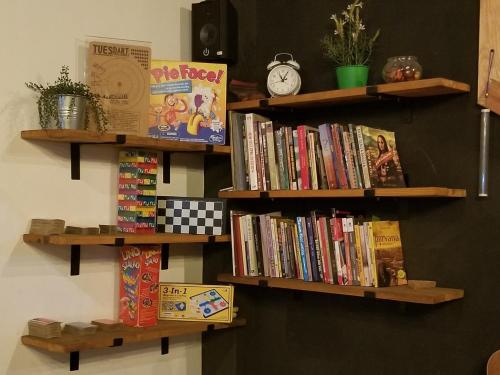 a wall with wooden shelves filled with books at CoffeeBunk Hostel in Tangerang