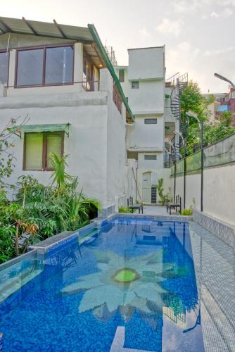 a swimming pool in front of a building at Yogved Hospitality & Resort in Rishīkesh