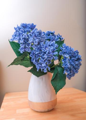 a vase filled with blue flowers on a table at Lộc Thiên Ân hotel in Bien Hoa