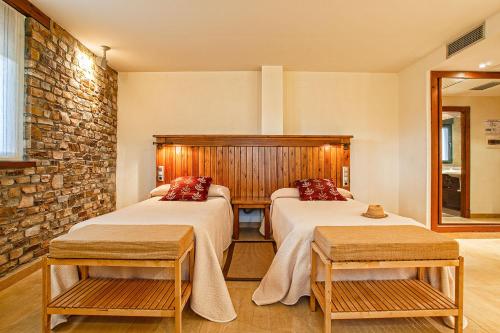 a room with two beds and a brick wall at El Molino de Losacio in Losacio de Alba