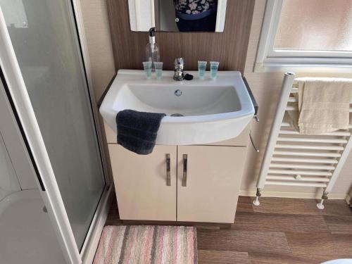 a bathroom with a white sink and a shower at pets stay free 8 berth lux van heacham beach in Heacham