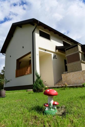 a red and white house with a mushroom in the grass at Villa Diva Grabovčeva in Rakovica