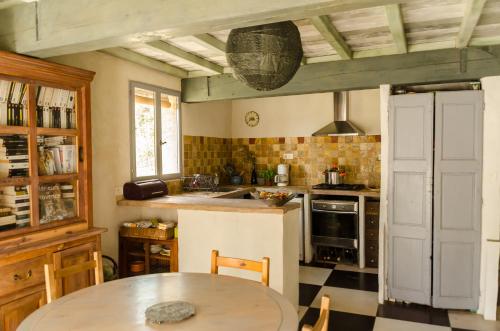 cocina con mesa y fogones horno superior en L'Oustaou des Monges, en Mollans-sur-Ouvèze