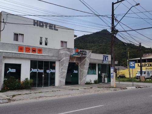 a white building on the side of a street at Vegas Hotel in Matinhos