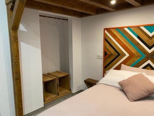 ein Schlafzimmer mit einem Bett und einem Gemälde an der Wand in der Unterkunft Apartamentos La Cámara II Córdoba Corredera in Córdoba