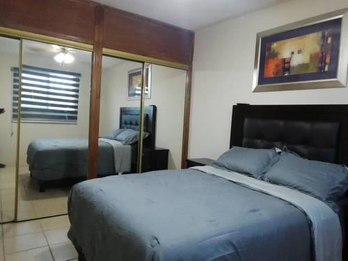 um quarto com 2 camas e um espelho em Departamento Equipado á 3 minutos del Consulado americano 2 RECAMARAS em Manuel F. Martínez