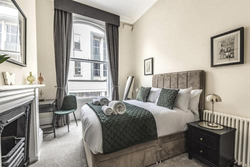 een slaapkamer met een groot bed en een open haard bij Rowntree One - Stunning Apartment- Grade II listed in York