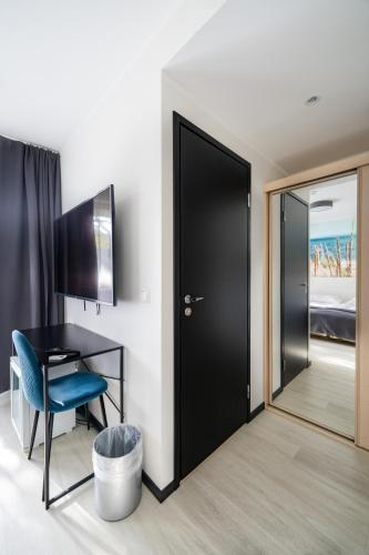 a room with a black door and a desk and a chair at Hotel NOSPA in Kuressaare