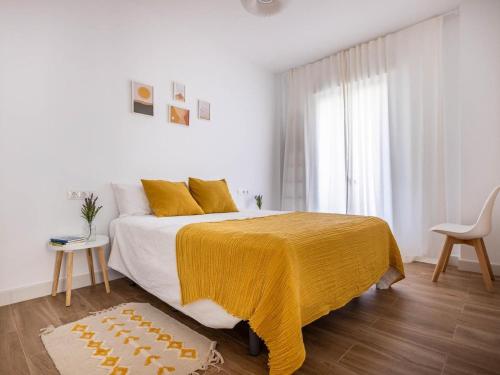 1 dormitorio blanco con 1 cama grande con manta amarilla en Gran plaza home - Vacacional Sevilla en Sevilla