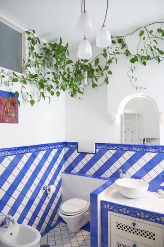 a blue and white bathroom with a toilet and a sink at B&B Milleduecento Luxury Room in Salerno