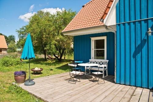 a wooden deck with a table and a blue building at Onkel-Blau-Ferien-in-Troja in Lärz