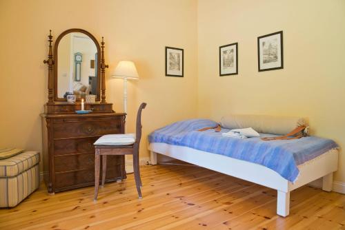 a bedroom with a bed and a table and a mirror at Onkel-Blau-Ferien-in-Troja in Lärz