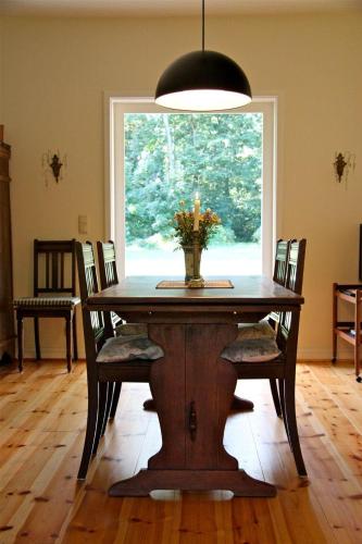a dining room table with chairs and a window at Tante-Braun-Ferien-in-Troja in Lärz