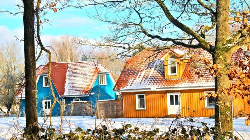 an orange and blue house in the snow at Tante-Braun-Ferien-in-Troja in Lärz